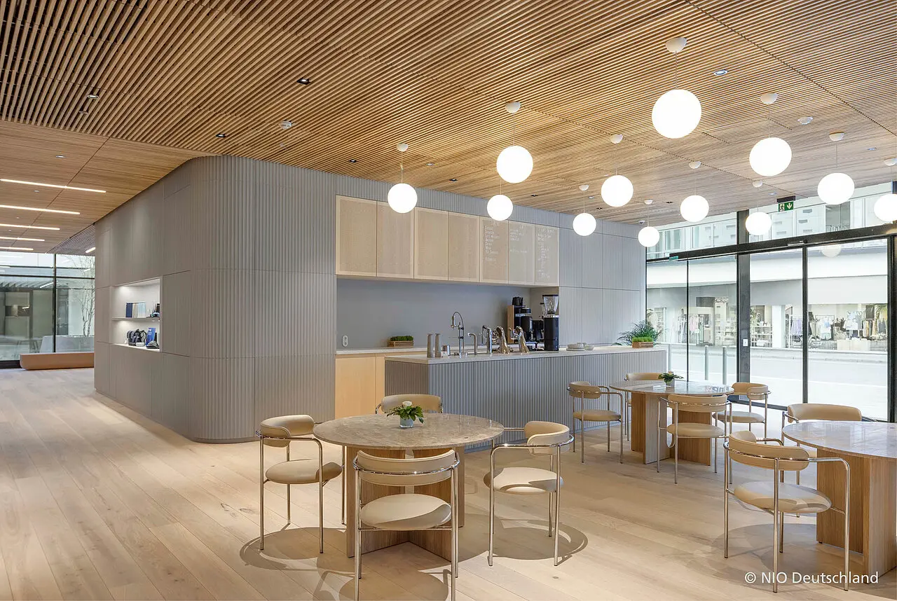 Merton & imi Wave - Smukt indbygget skabsvæg i imi Wave paneler, fra gulv til loft og med afrundede hjørner. Her indrammer panelerne et flot egetræs køkken samt beklædning på køkken ø med marmor bordplade i sandfarvede nuancer. 